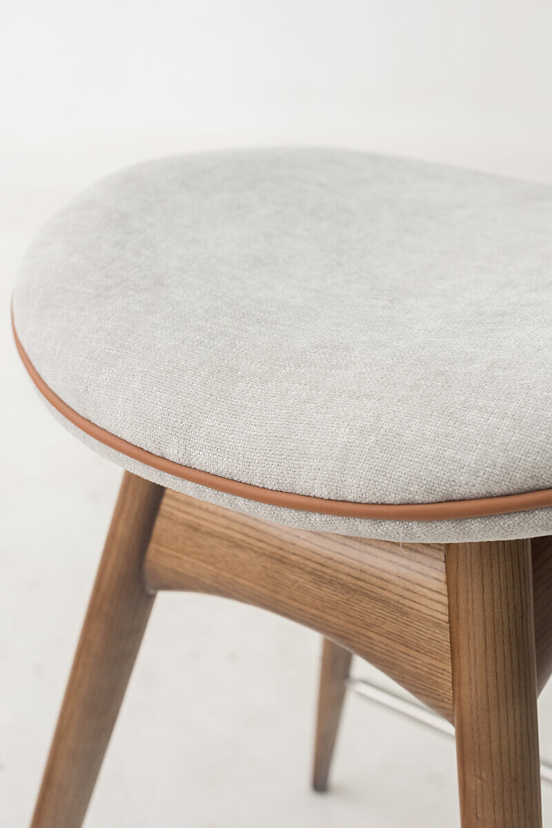 Close-up of the saddle-shaped upholstered seat on the Andy bar stool