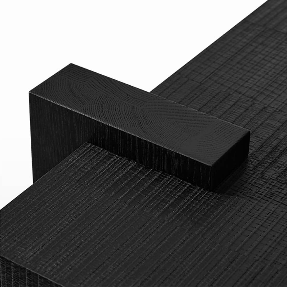 Close-up of Anya Coffee Table black wrap-around solid oak leg