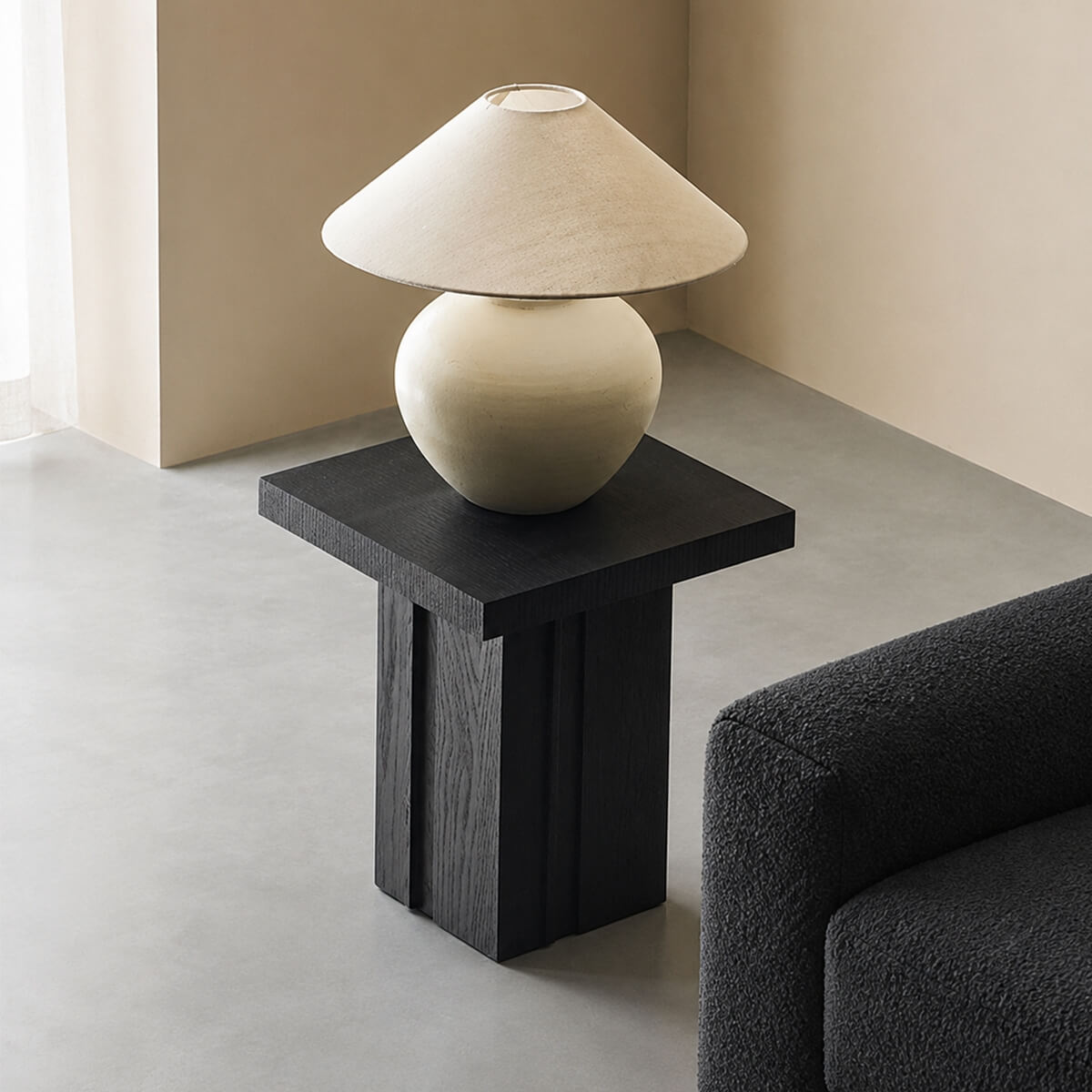 Anya oak side table beside a sofa with a sculptural table lamp in a contemporary living room.
