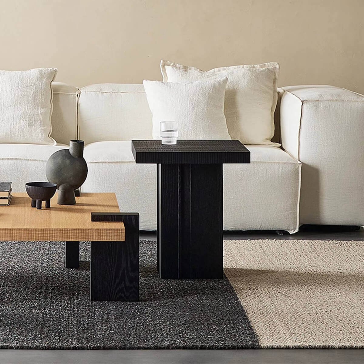 Anya oak side table beside a contemporary sofa with a glass of water.