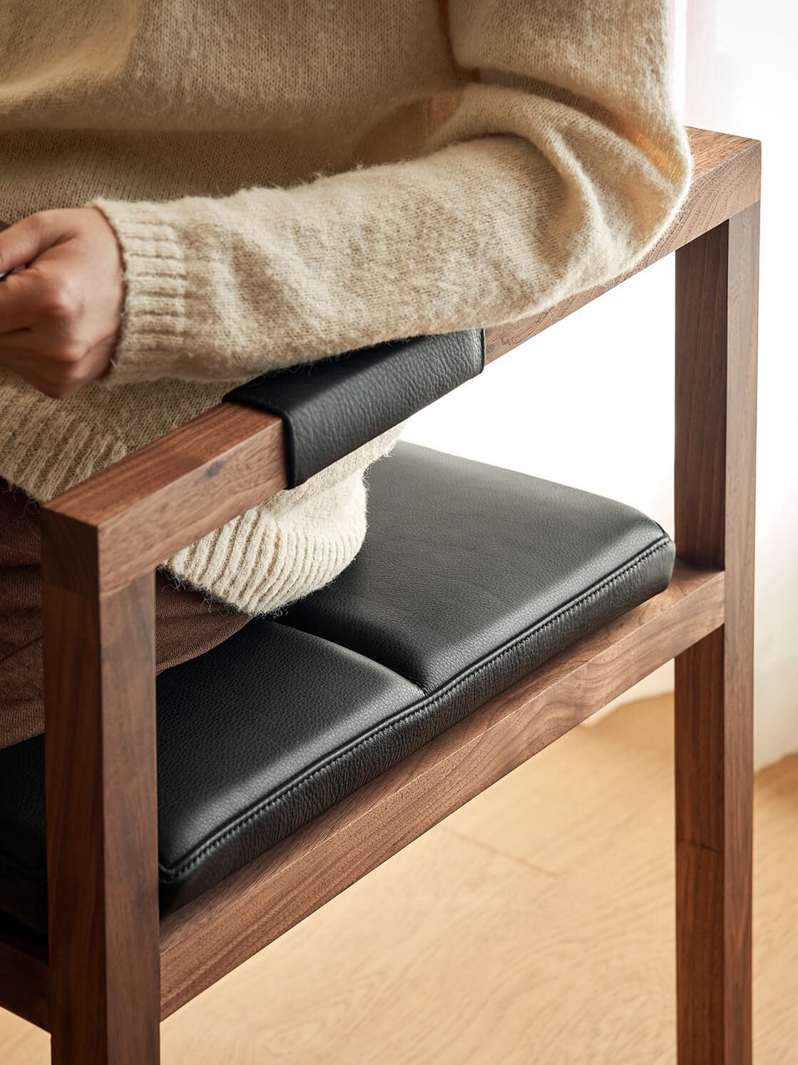 Person seated on Arden dining chair showing comfort and arm support