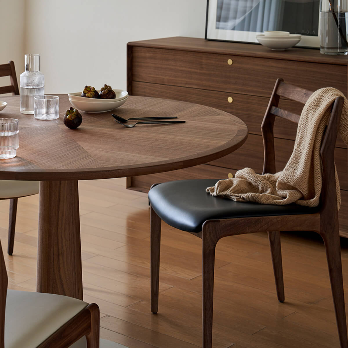 Beck walnut leather dining chair beside round timber dining table