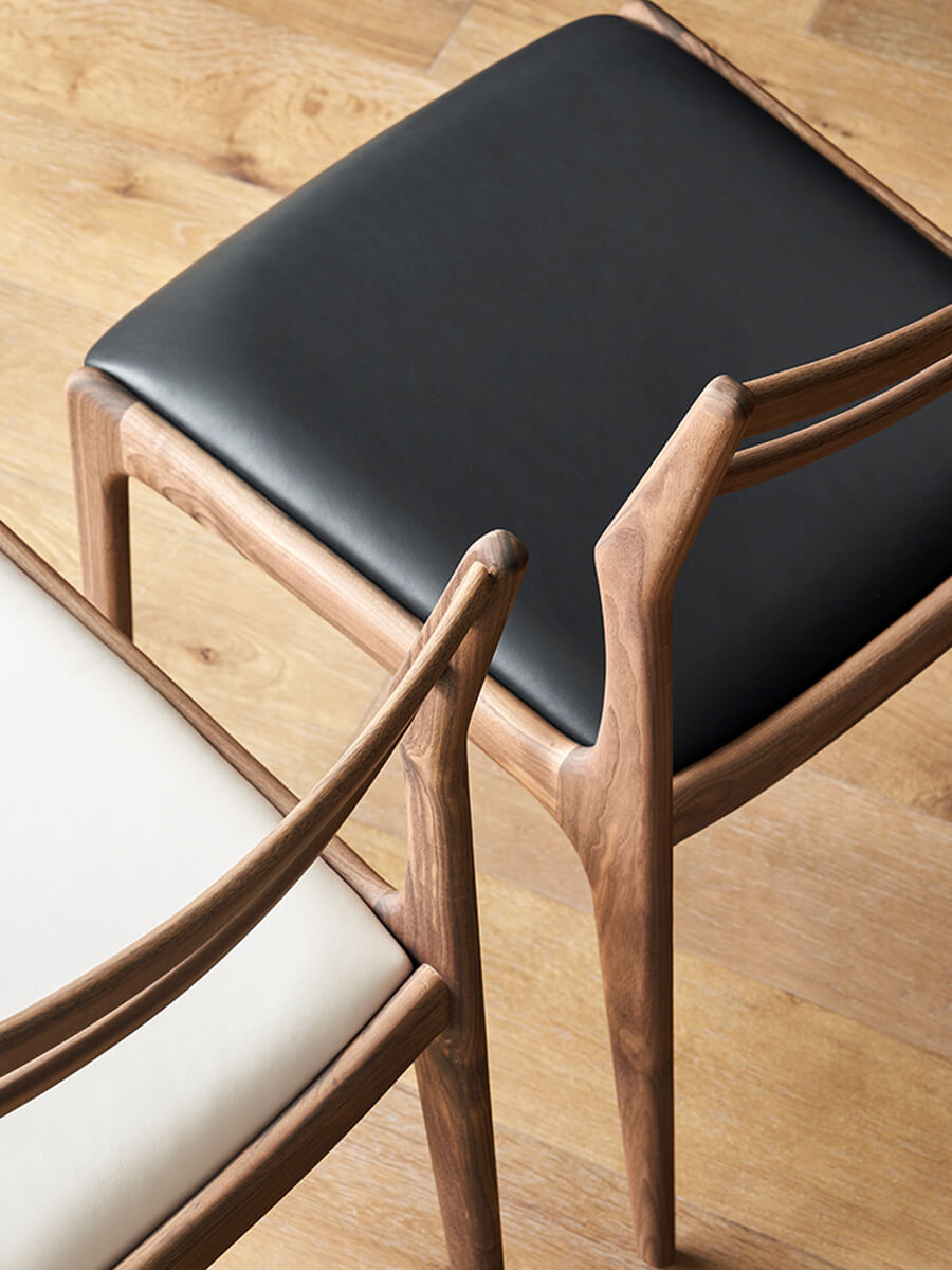 Beck dining chair walnut wood frame and black leather seat detail