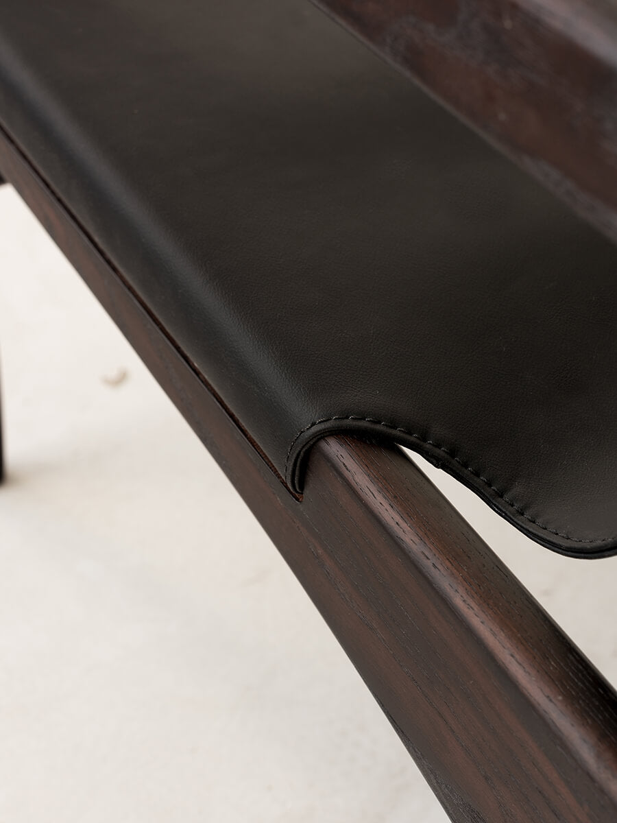 Close up detail of the Carey armchair black sling seat upholstery