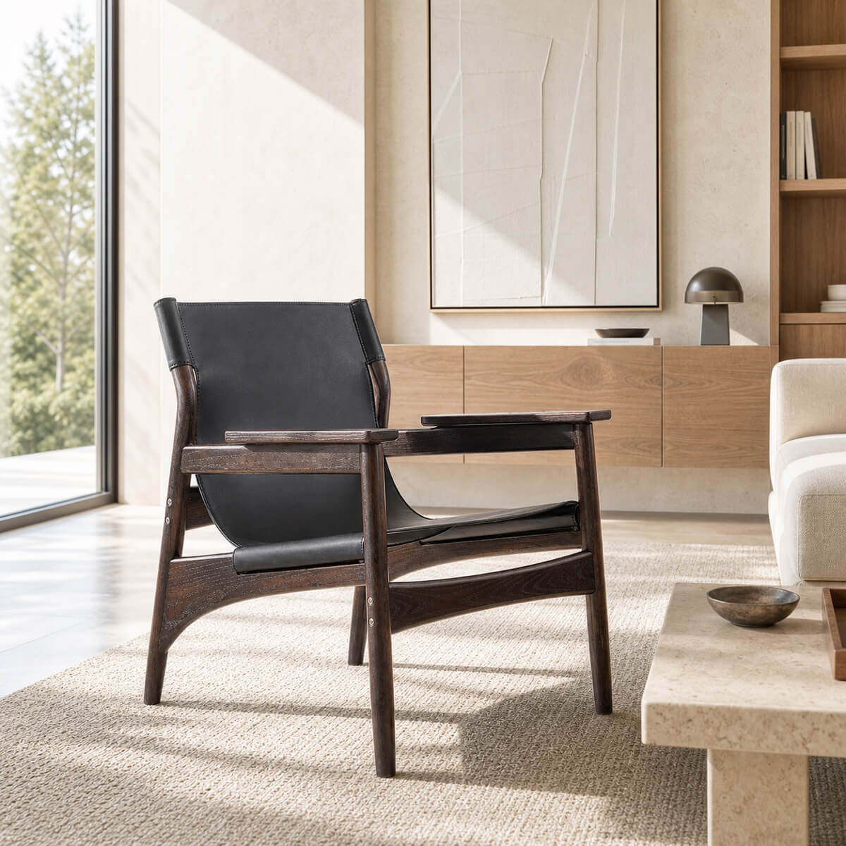 Carey armchair with dark ash timber frame and black sling seat in a contemporary living room