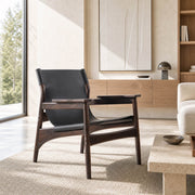 Carey armchair with dark ash timber frame and black sling seat in a contemporary living room