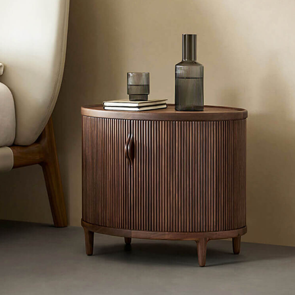 Charlie Tambour Bedside Table in Walnut beside a bed
