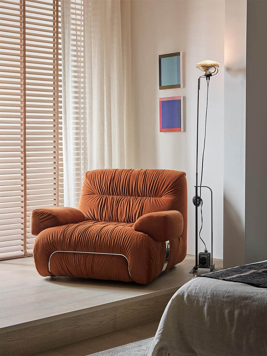 Cloudscape Armchair in rust fabric upholstery styled in a modern bedroom