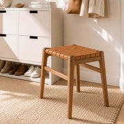 Connar saddle leather stool in a Scandinavian entryway beside a white shoe cabinet