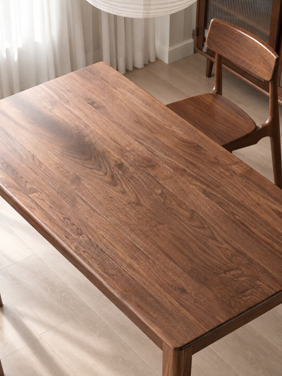 Close-up of Dalton solid walnut dining table showing natural walnut wood grain and smooth tabletop finish