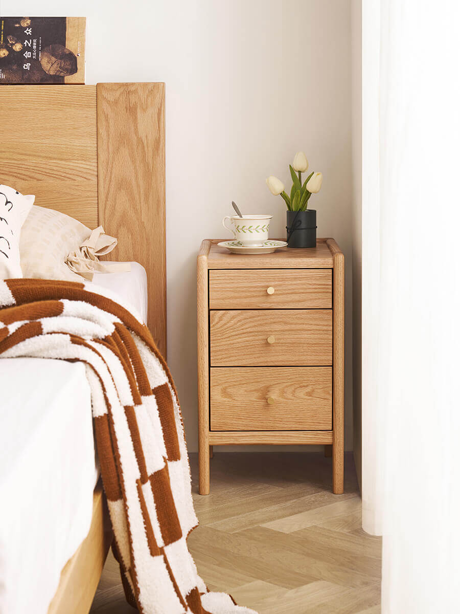 Compact Denmark Solid Oak Bedside Table beside a timber bed