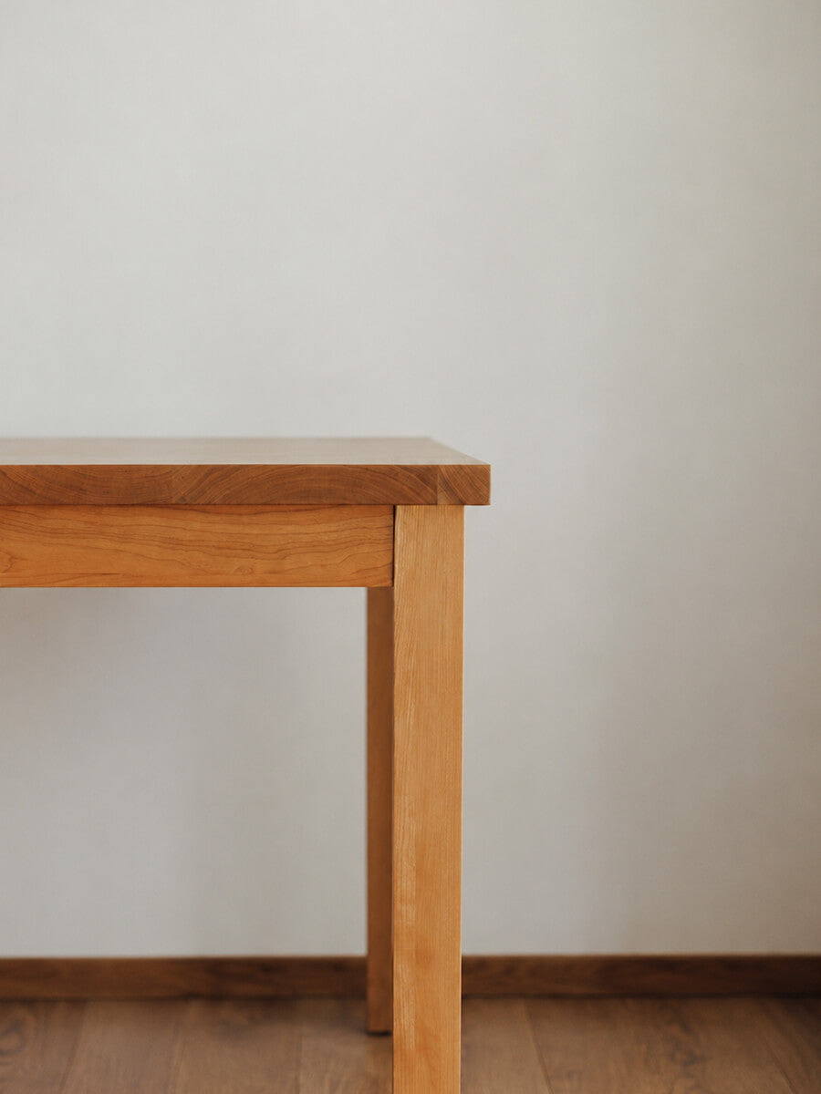Close-up of the solid cherry timber leg and tabletop on the Edge Solid Cherry Classic Dining Table