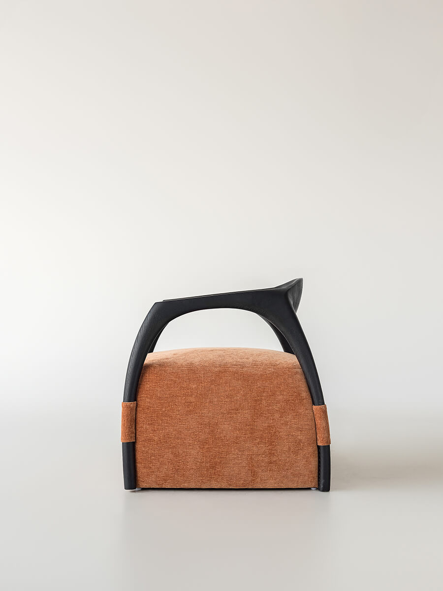 Front view of the Eland Armchair with upholstered seat and sculptural timber frame