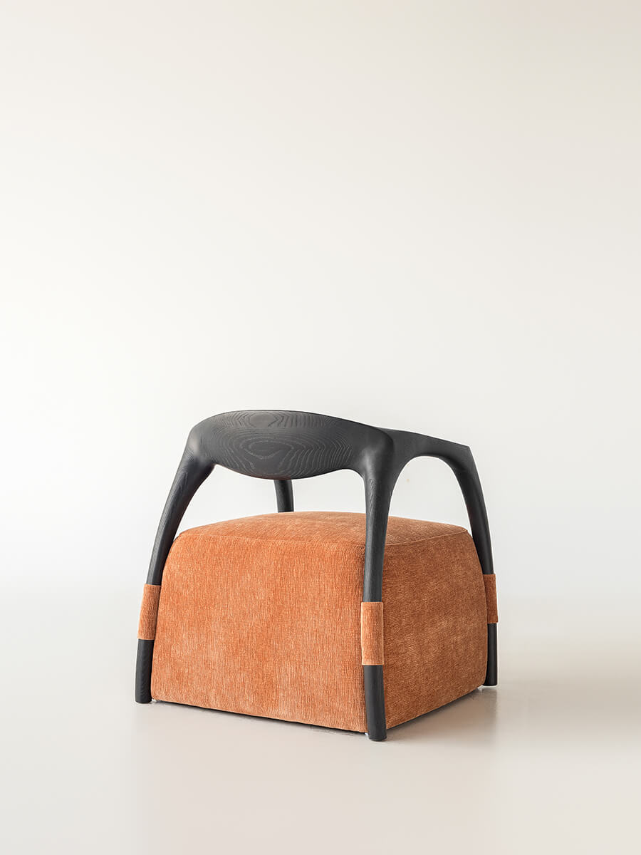 Rear angle view of the Eland Armchair highlighting its curved ash wood frame