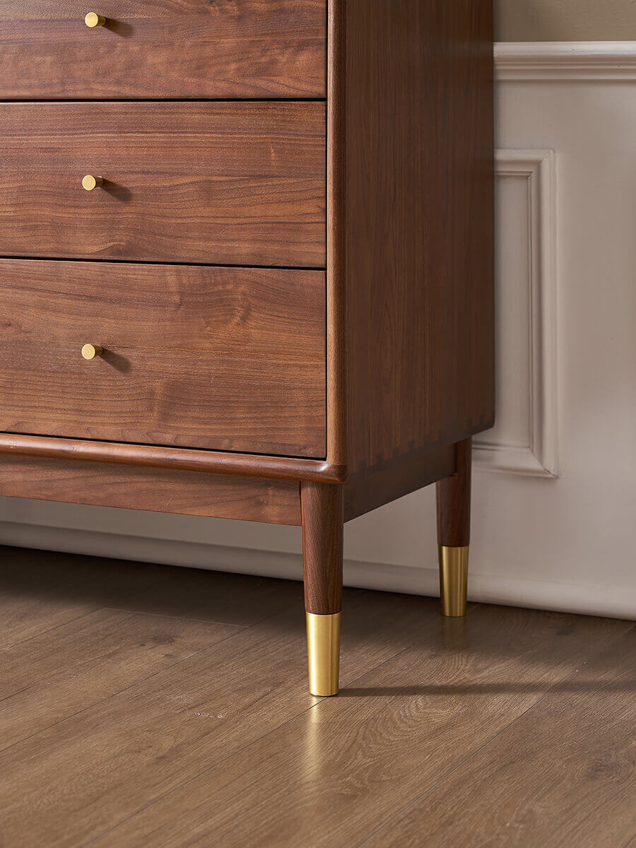 Brass-capped solid walnut legs of the Elara Chest of Drawers
