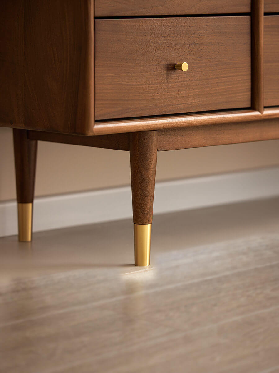 Solid walnut leg detail with brass cap on the Elara Sideboard