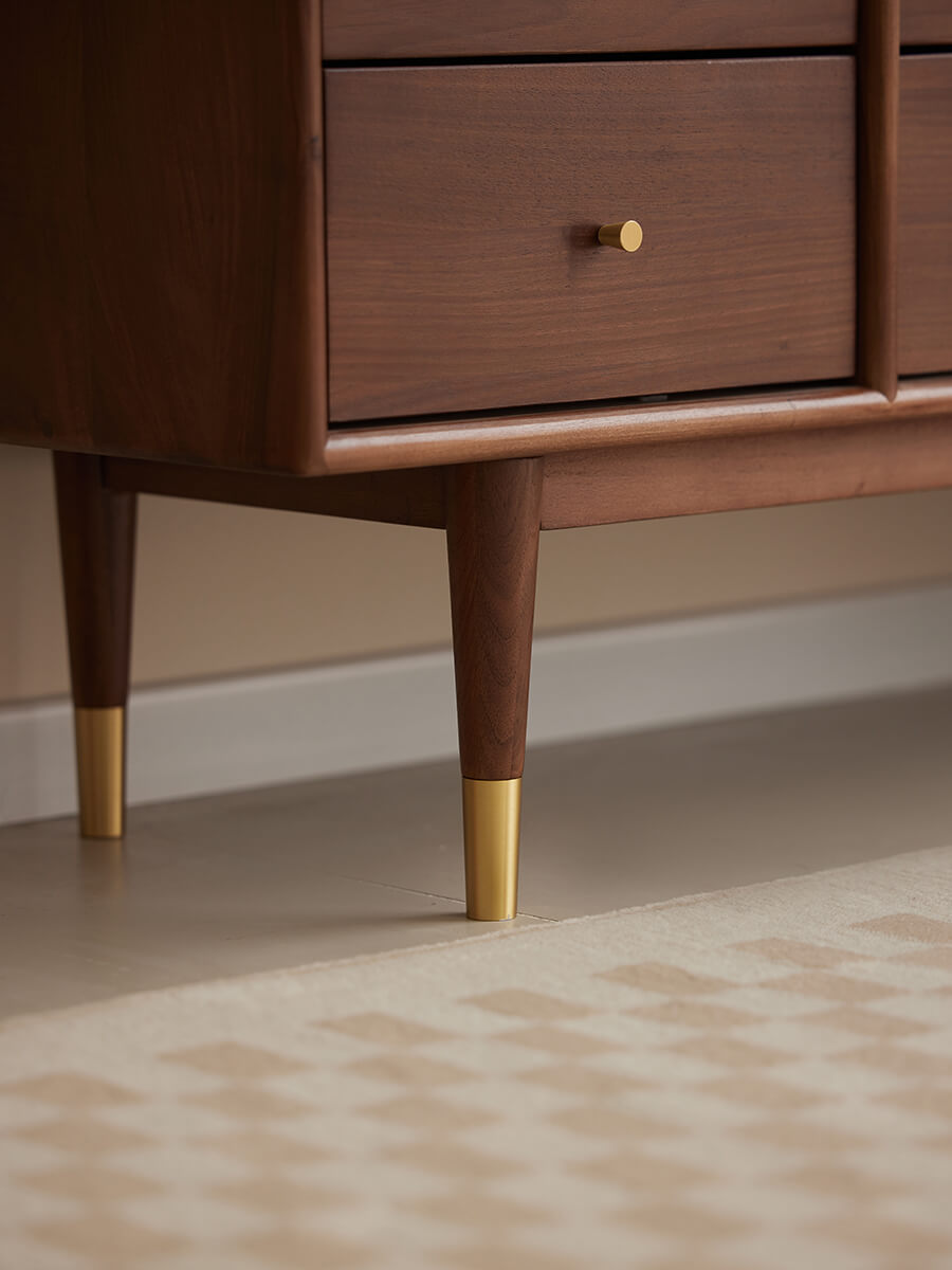 Solid walnut leg detail with brass cap on the Elara Sideboard