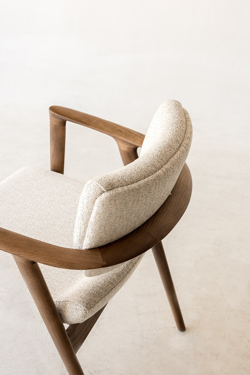 Close-up of Emerson dining chair curved timber arm and upholstered backrest
