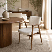 Emerson dining chair with upholstered seat and curved timber arms beside a timber dining table