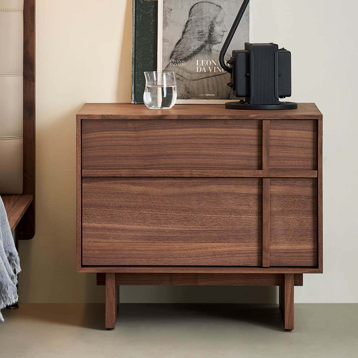 field walnut bedside table beside a contemporary bed