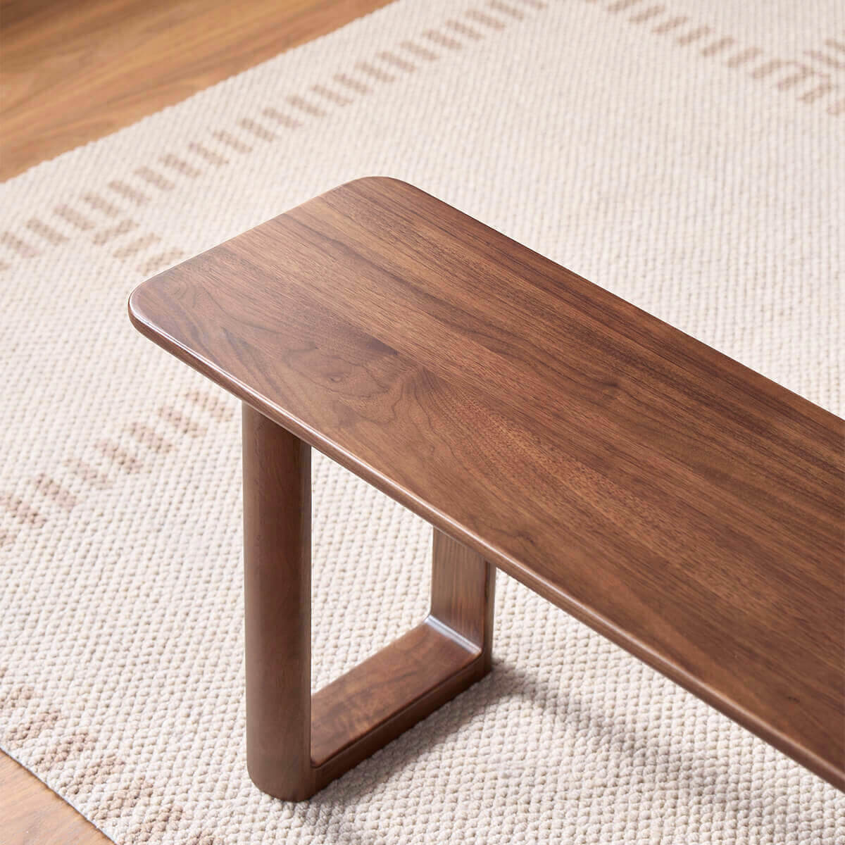 Rounded edge and solid walnut grain detail of the Forma Dining Bench