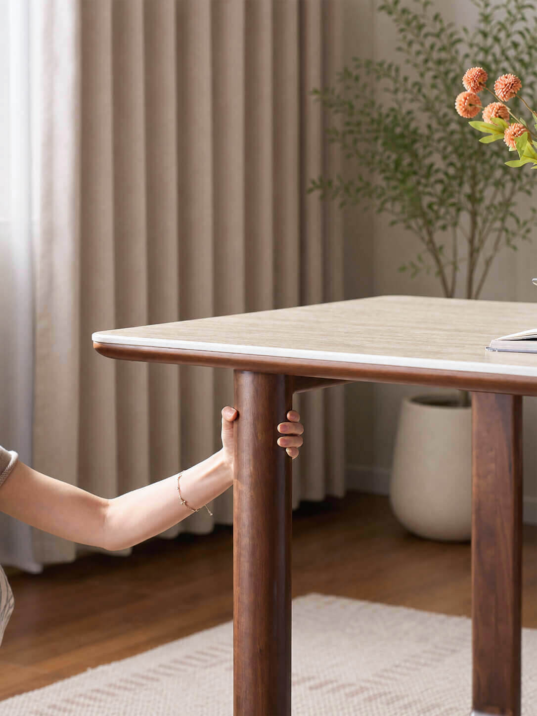 Close-up of the solid walnut leg on the Forma Sintered Stone Dining Table