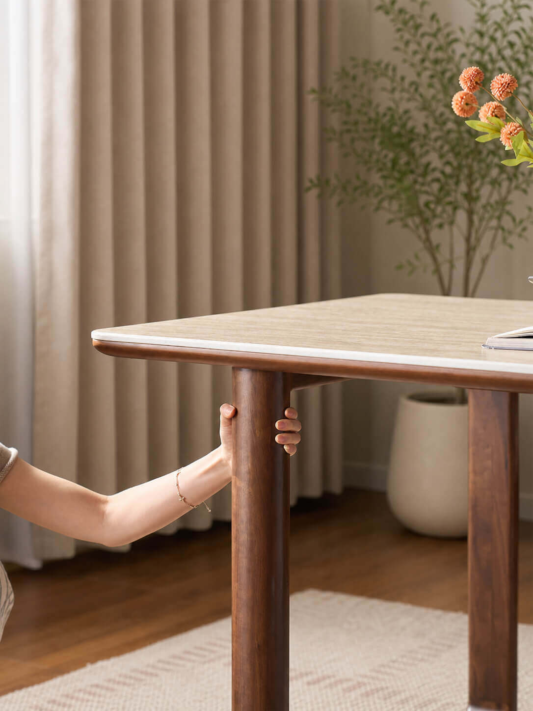 Close-up of the solid walnut leg on the Forma Sintered Stone Dining Table