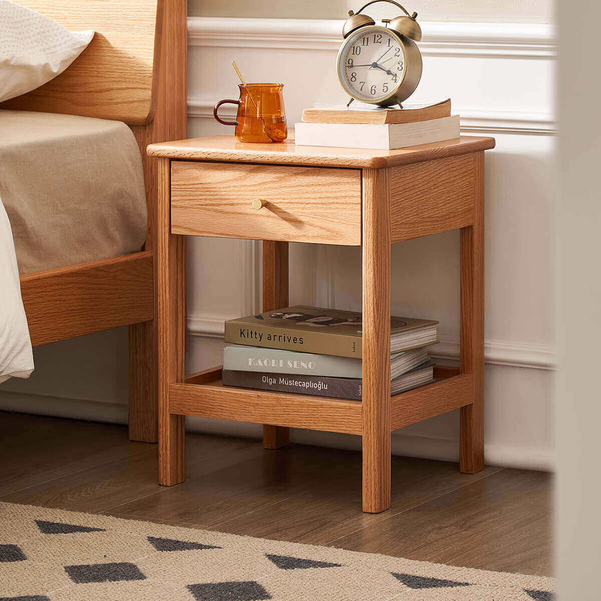 Gamo solid oak bedside table beside an oak bed with drawer and open shelf