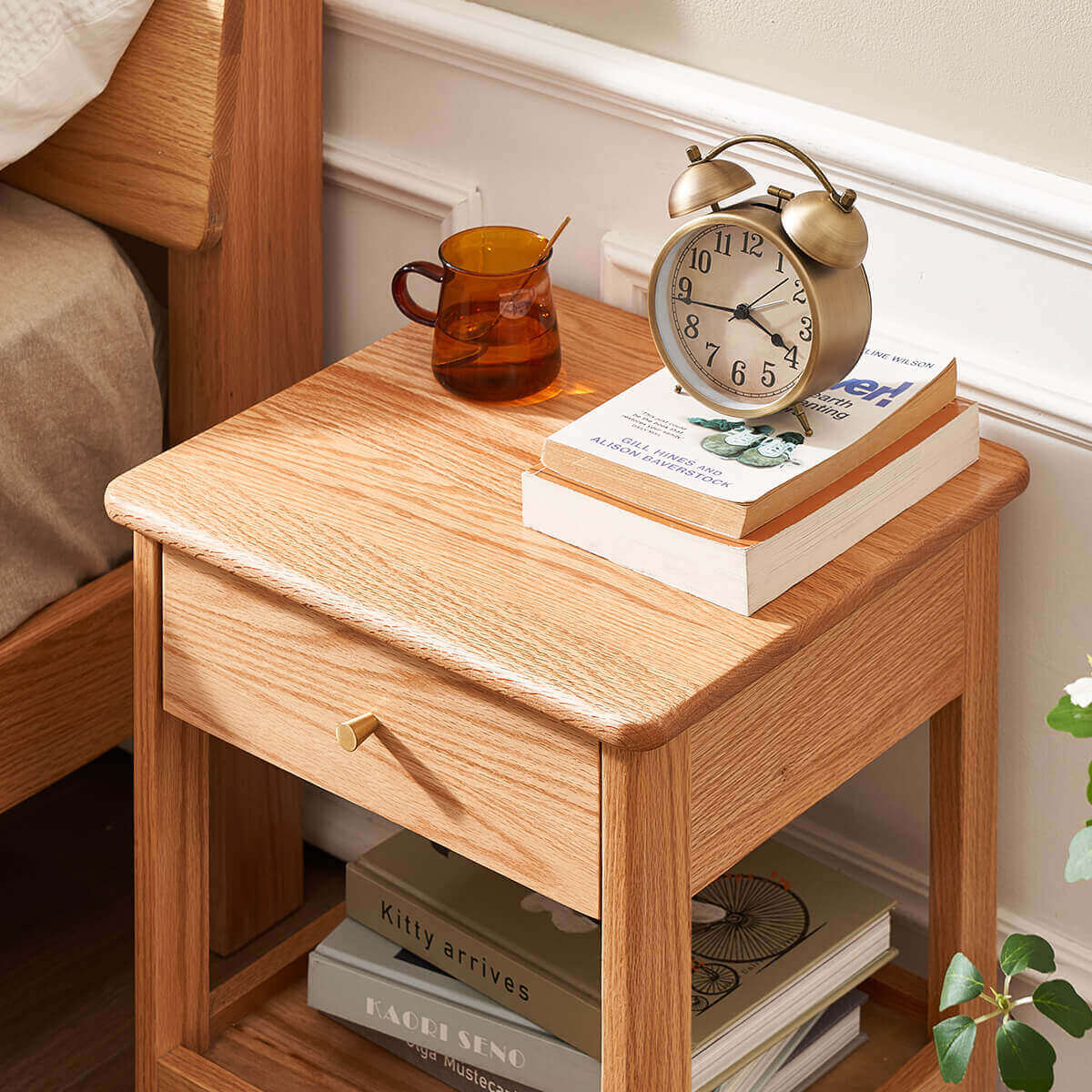 Top view of Gamo solid oak bedside table beside a bed