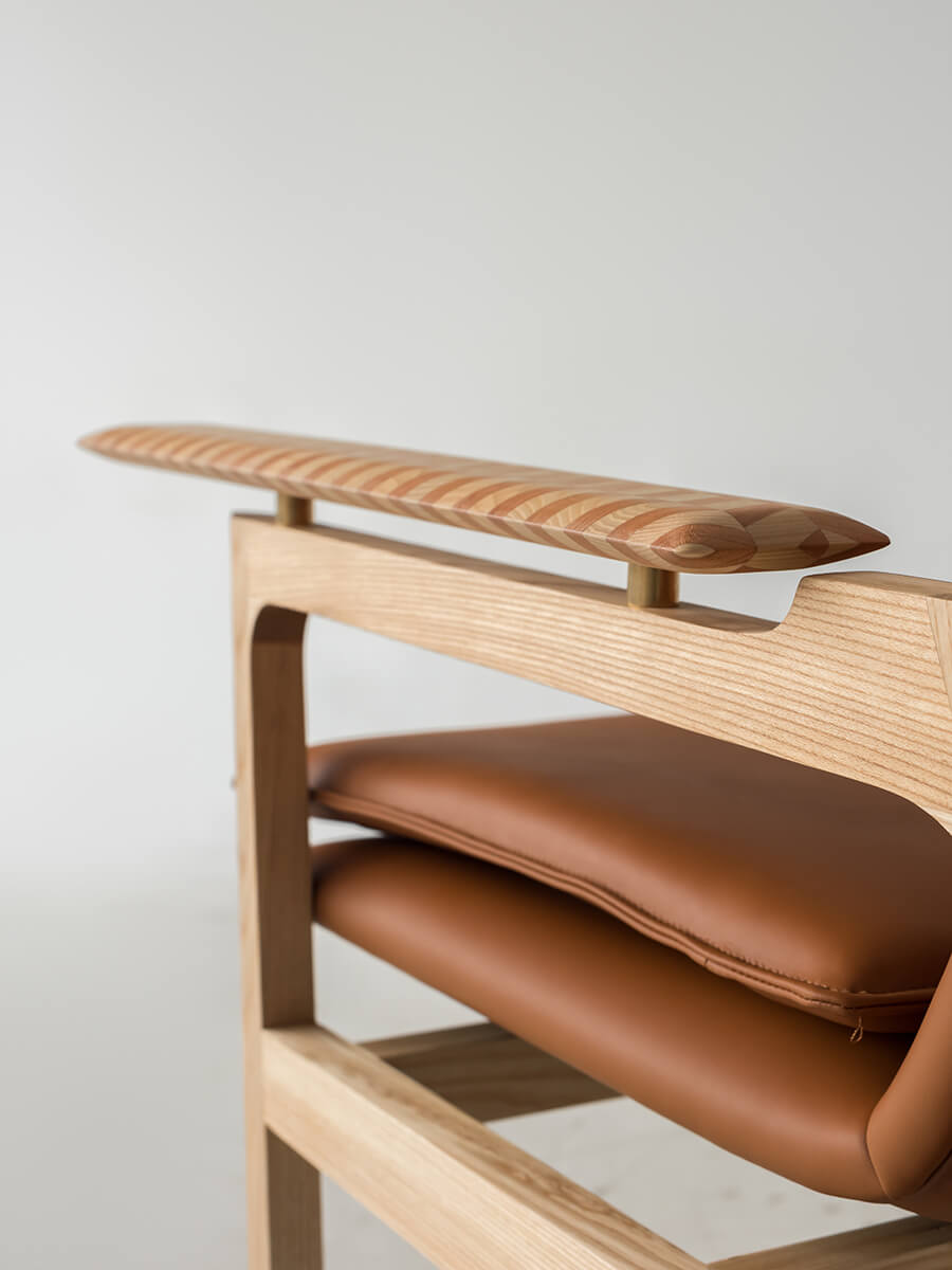 Detail of the Grant armchair geometric timber marquetry armrest