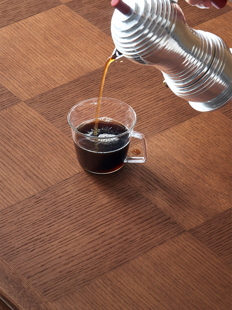 Coffee spill test on Grid checkerboard oak veneer dining table surface