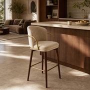Harrington Bar Stool with beige upholstery and brass frame detail in modern kitchen