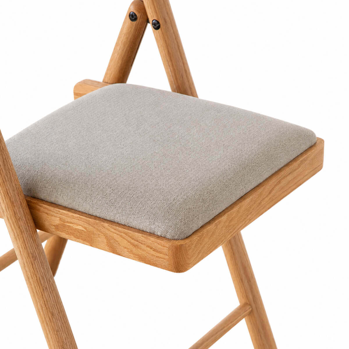 Upholstered fabric seat detail of the Hedrich solid oak folding chair
