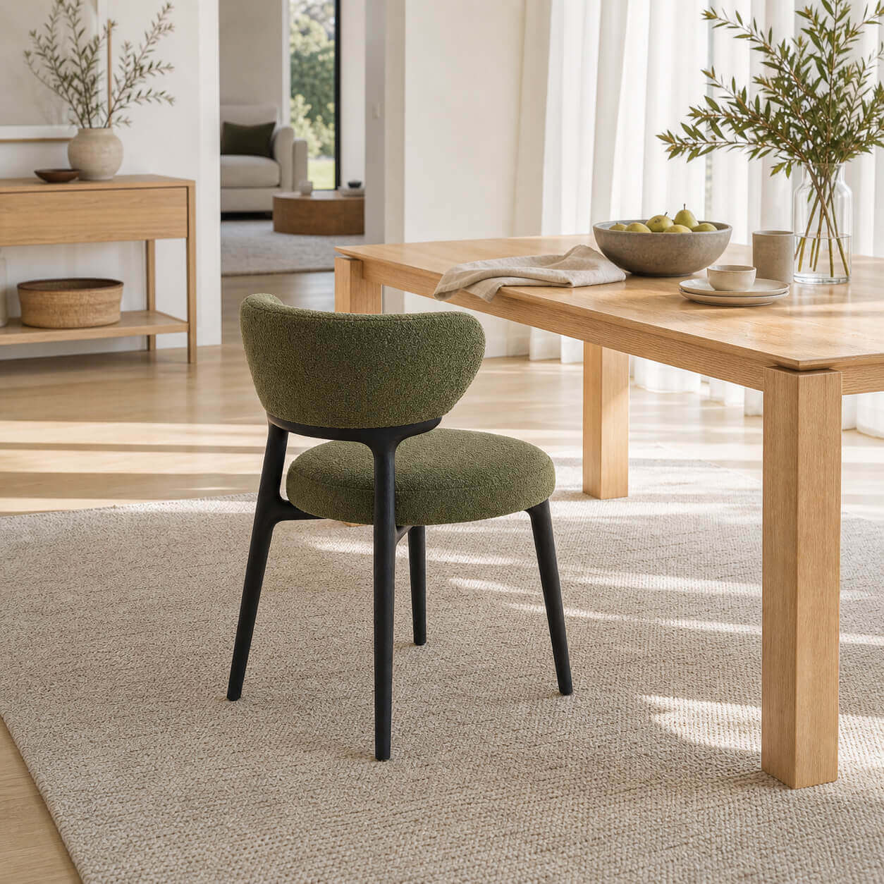 Green boucle Klara dining chair beside oak dining table