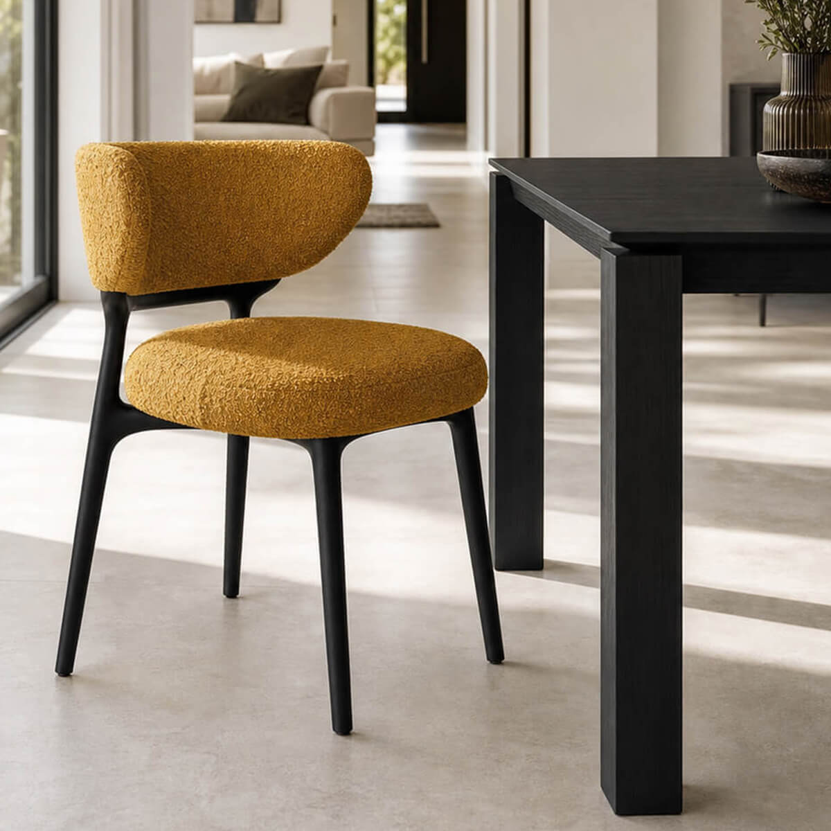 Klara dining chair in yellow boucle fabric beside black dining table