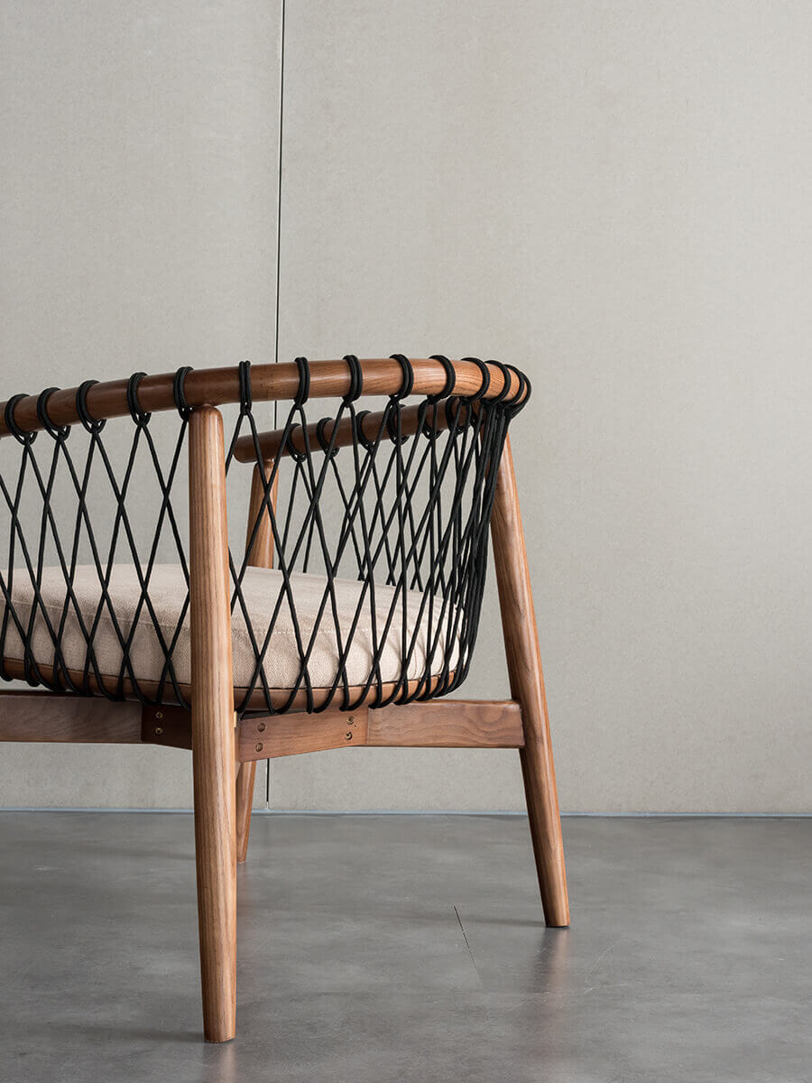 Side view of the Kniss woven armchair with hand-woven detailing