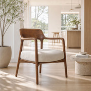 Kyra armchair with solid timber frame and flowing timber arms in a contemporary living room