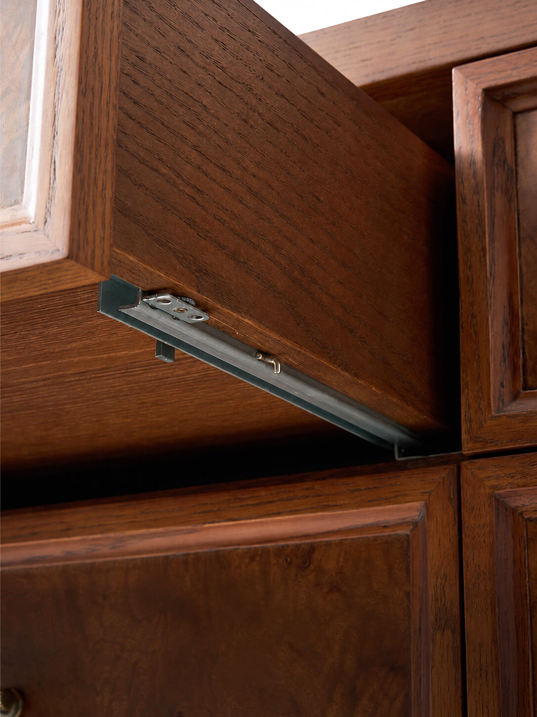 Concealed undermount drawer runner on Louvre burl wood chest of drawers