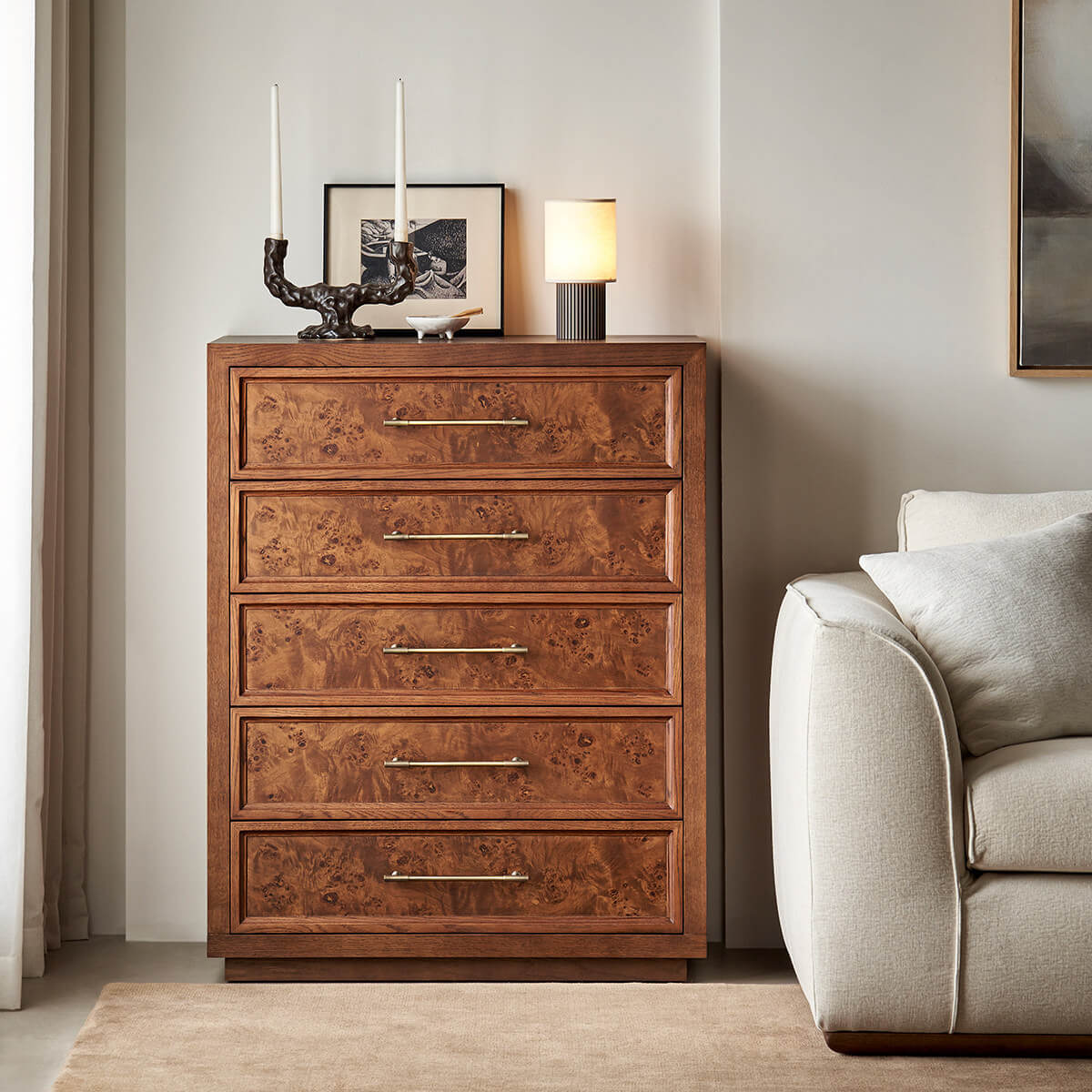 Louvre burl wood five-drawer chest of drawers beside a sofa