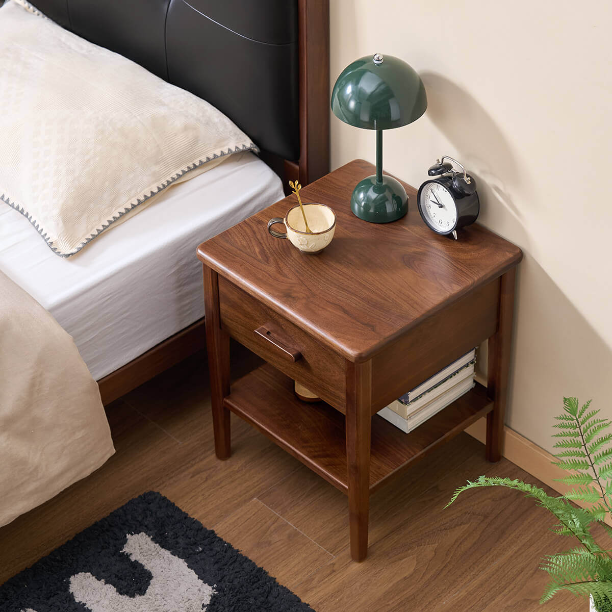 Luca Solid Walnut Bedside Table beside a bed