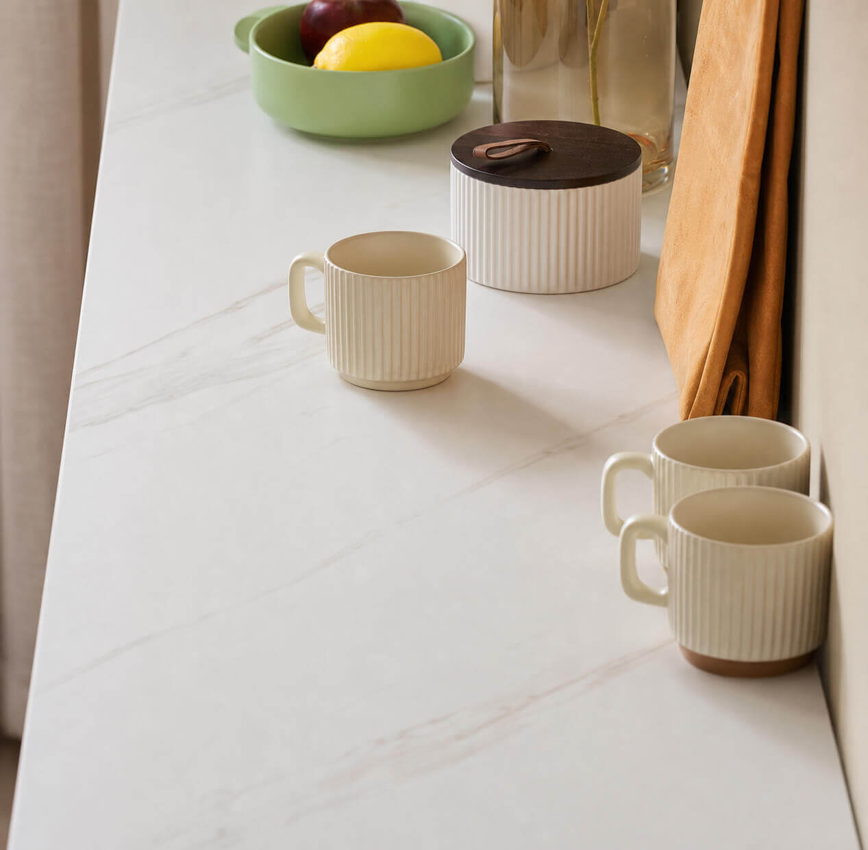 Close-up of the Mora Sideboard sintered stone top with cups and dining accessories