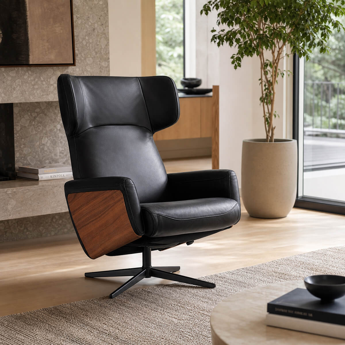 Noelia swivel recliner chair in black semi-aniline leather with walnut side panels in a modern living room