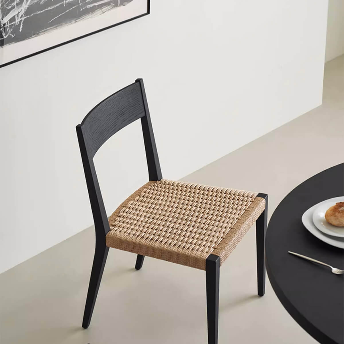 Noir Dining Chair with paper cord seat beside dining table