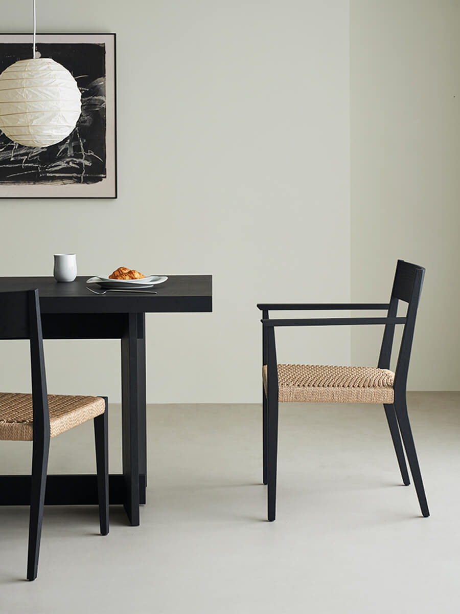 Handwoven paper cord seat of Noir Dining Chair with black dining table