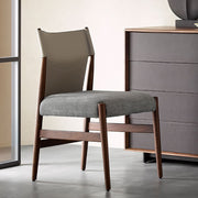 Nora dining chair with saddle leather backrest and grey upholstered seat beside timber furniture