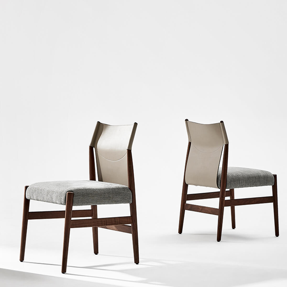 Pair of Nora dining chairs with saddle leather backrests and upholstered seats