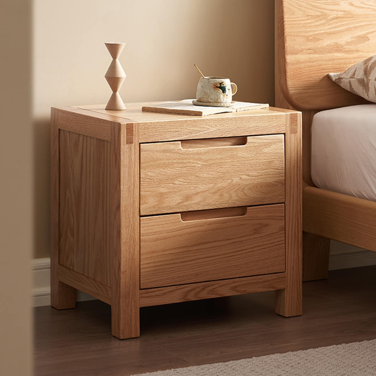 Side view of the Norman Solid Oak Bedside Table beside a bed