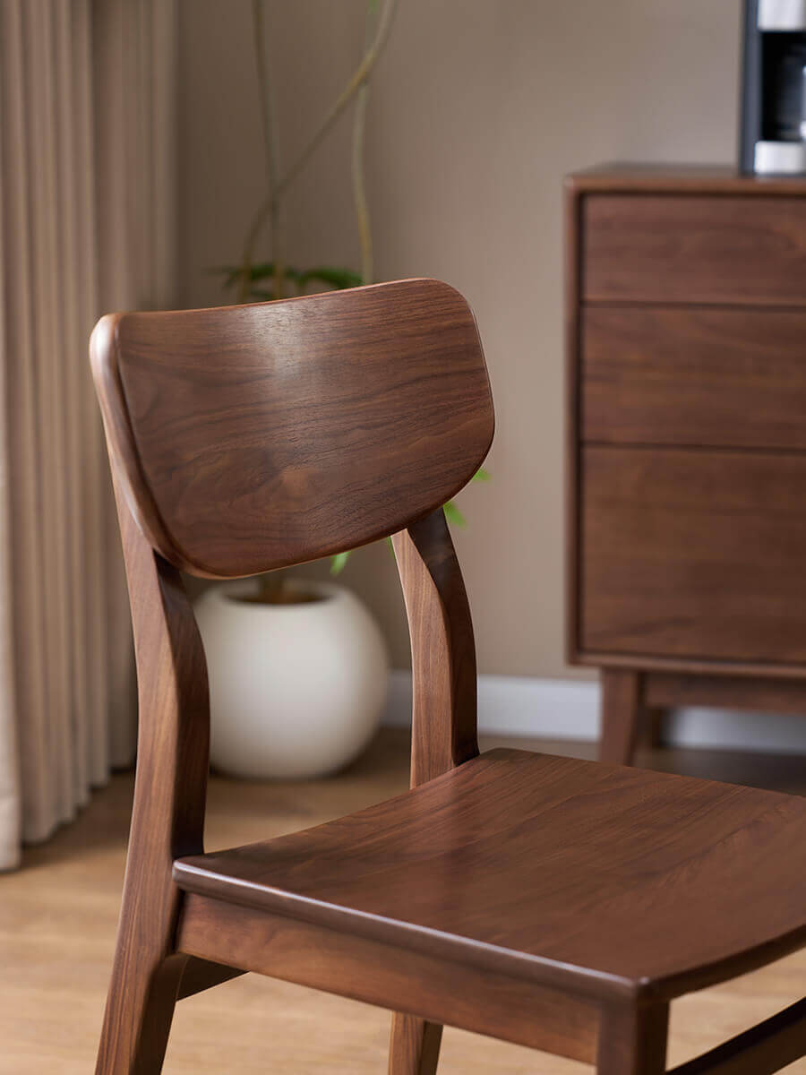 Curved solid walnut backrest of the Oden Dining Chair