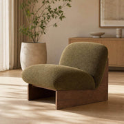 Pebble Accent Chair with sculptural timber base and upholstered seat in a contemporary living room