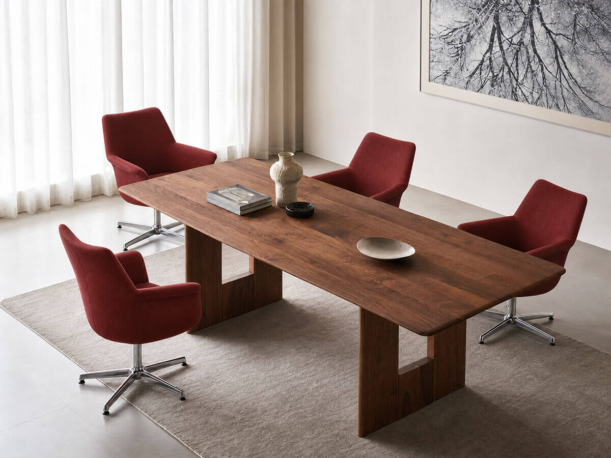 Pimento red swivel armchairs paired with a walnut dining table